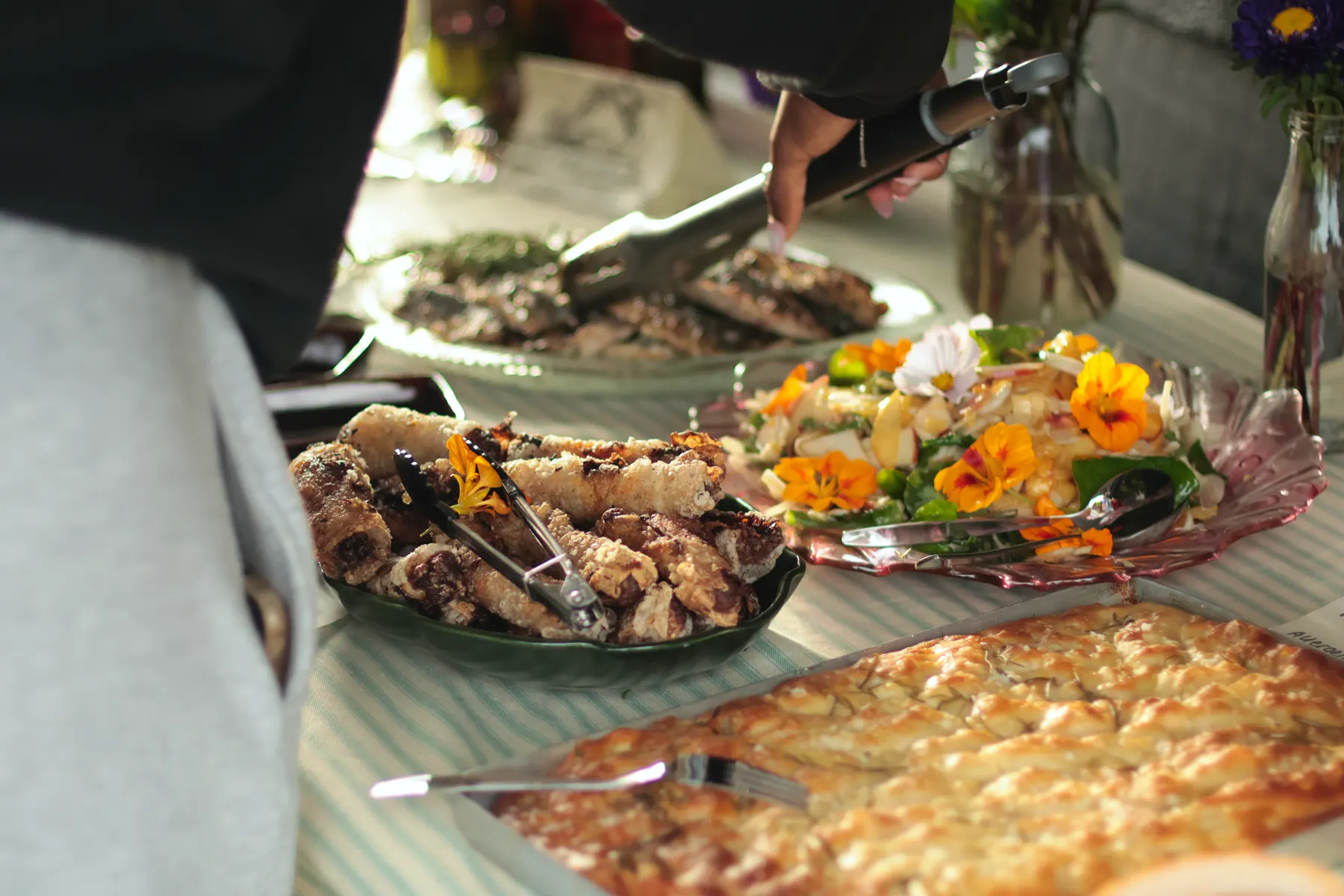 A communal table of fried fish, salad and baked dishes